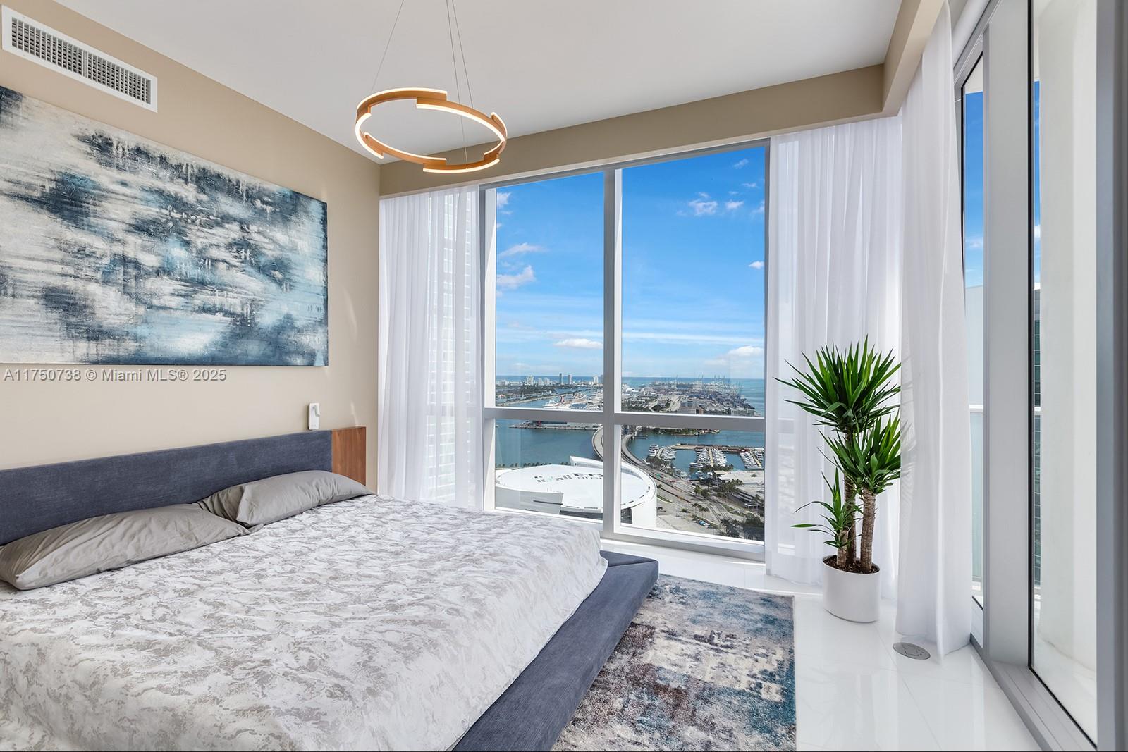 851 Northeast 1st Avenue, Unit 3611 Miami, FL 33132 - Photo 11 of 23 a bedroom with a large bed and a large window