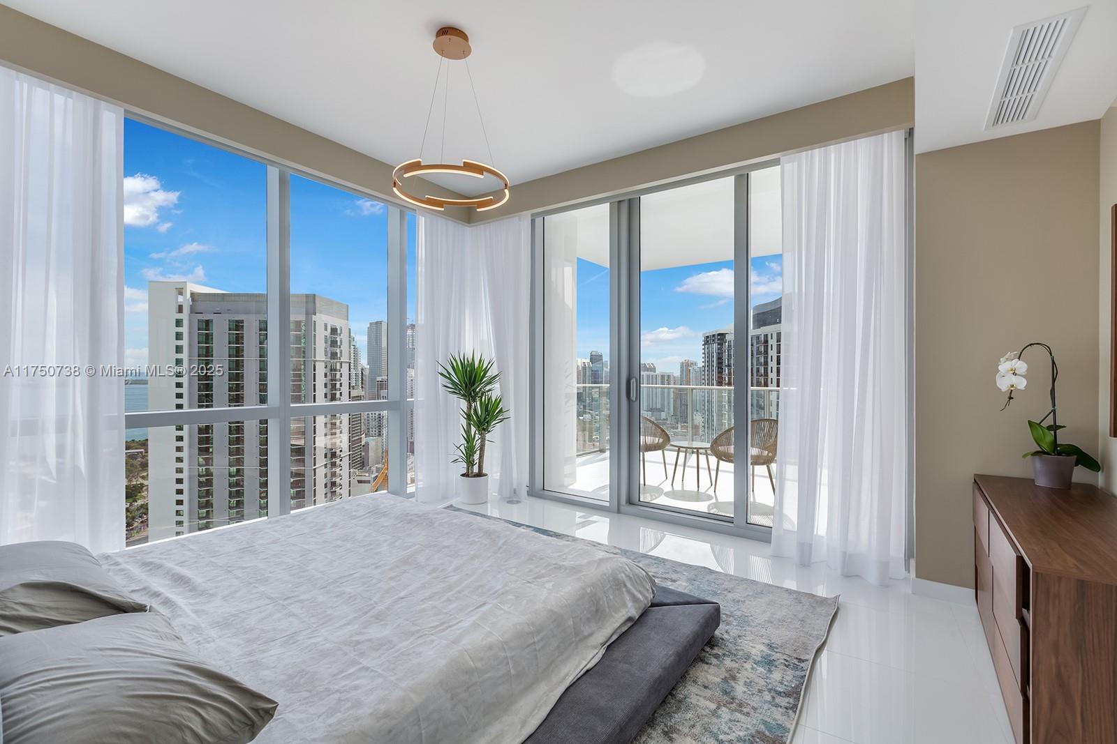 851 Northeast 1st Avenue, Unit 3611 Miami, FL 33132 - Photo 12 of 23 a bedroom with a large bed and a large window
