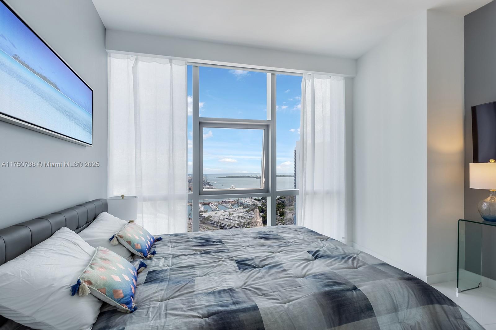 851 Northeast 1st Avenue, Unit 3611 Miami, FL 33132 - Photo 15 of 23 a bedroom with a bed and a window