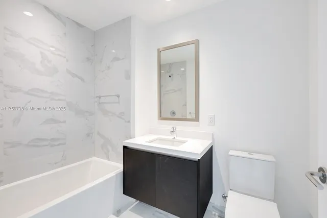 a bathroom with a sink a toilet and bathtub