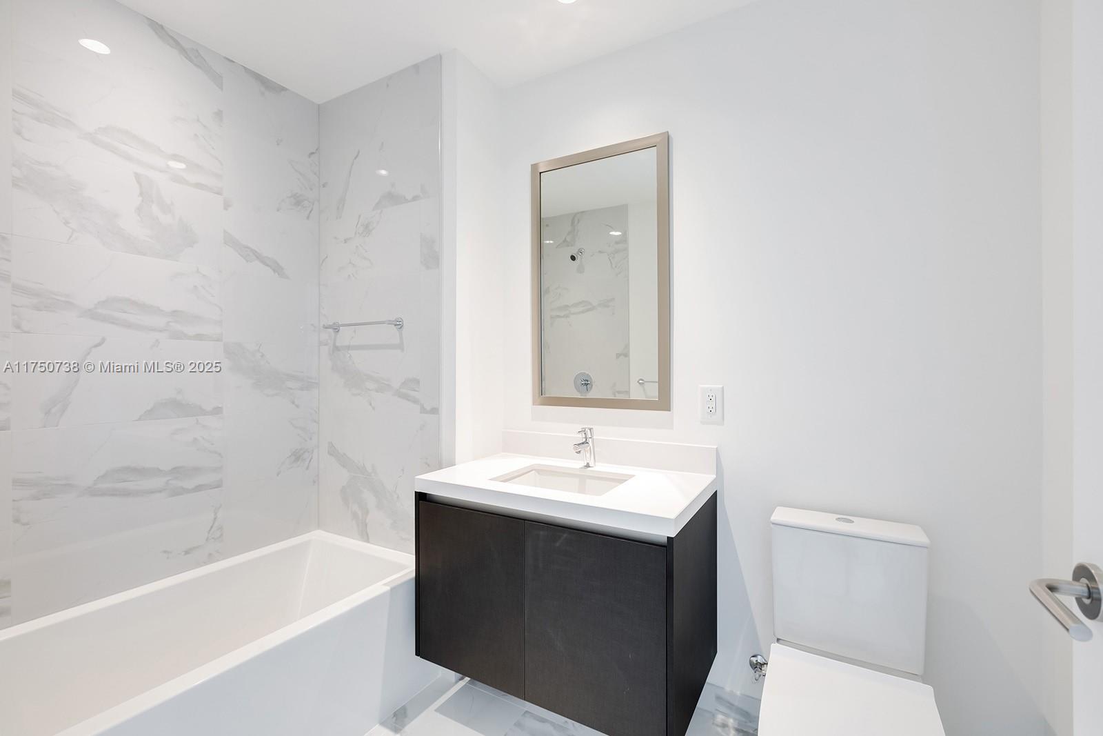 851 Northeast 1st Avenue, Unit 3611 Miami, FL 33132 - Photo 18 of 23 a bathroom with a sink a toilet and bathtub