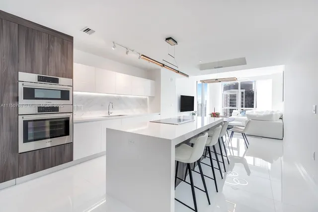 a kitchen with stainless steel appliances kitchen island granite countertop a stove and a sink