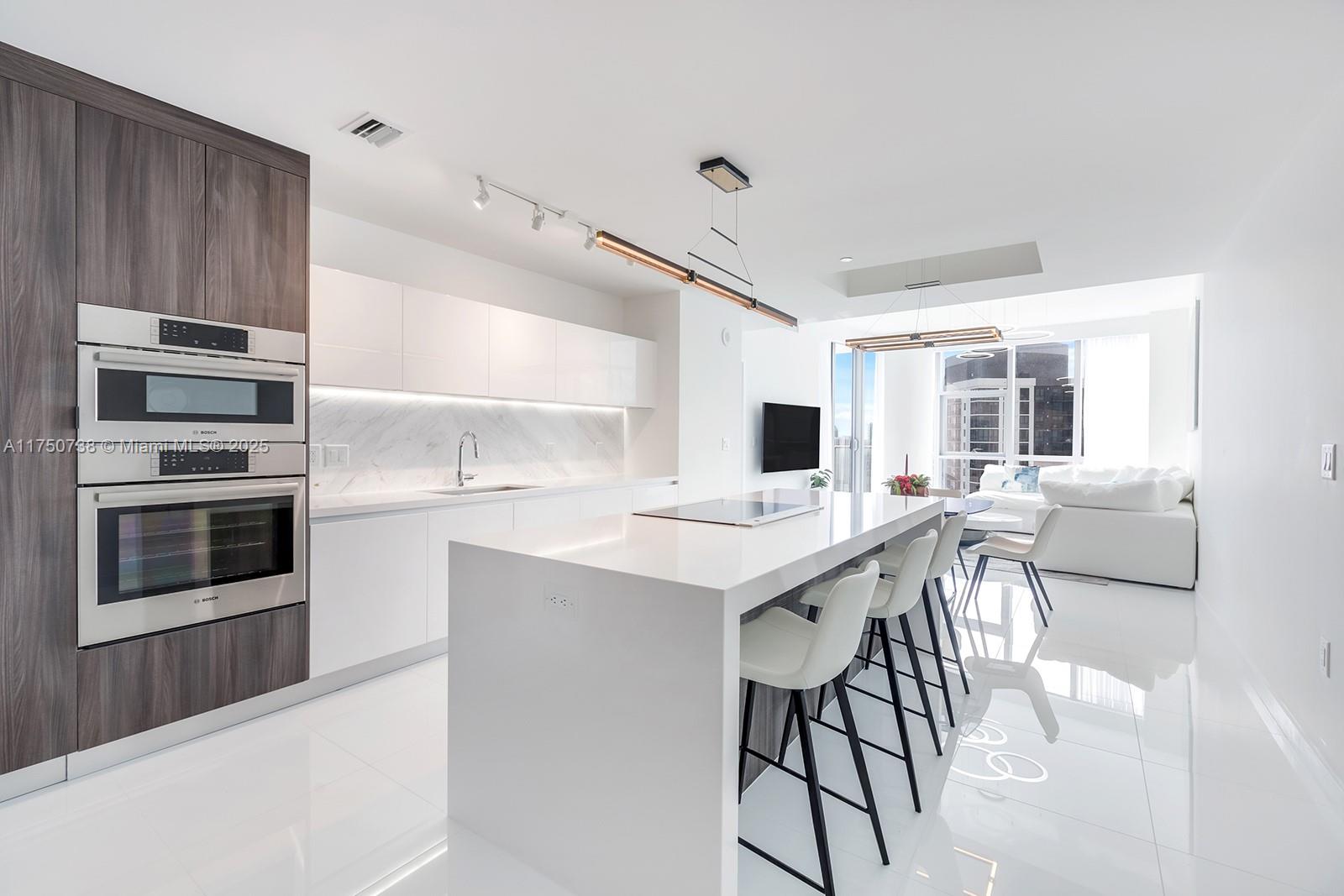 851 Northeast 1st Avenue, Unit 3611 Miami, FL 33132 - Photo 3 of 23 a kitchen with stainless steel appliances kitchen island granite countertop a stove and a sink