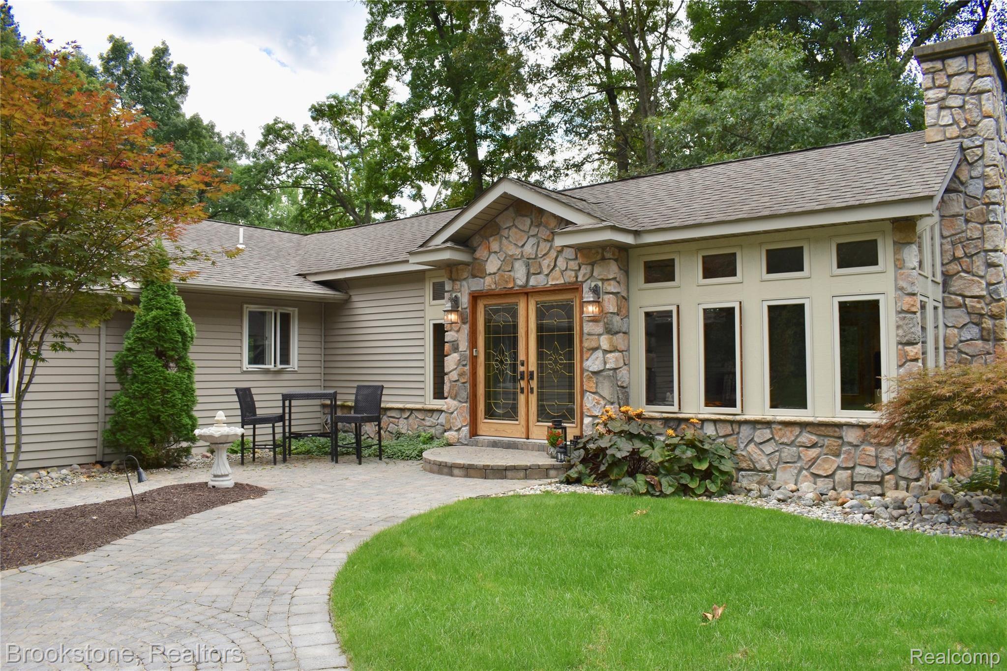 405 Baldwin Ridge Oxford, MI 48371 - Photo 21 of 54 NOW WE ARE BACK TO THE FRONT OF THE HOUSE. CHECK OUT THE BRICK PAVER WALK-WAY TO THE CLASSIC THE SITTING AREA WITH TABLE, BIRDBATH & "CLASSIC" FRONT DOUBLE LEADED GLASS DOORS