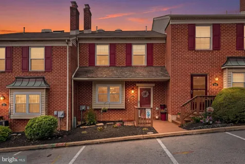front view of a brick house with a small yard