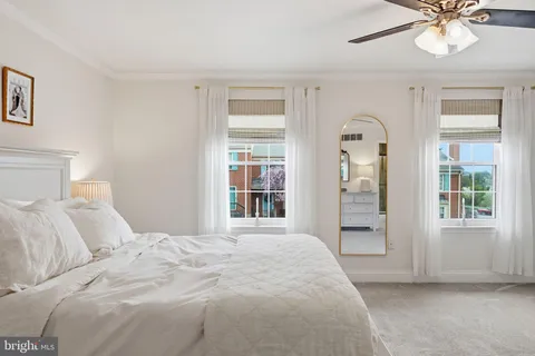 a bedroom with a bed a chandelier and a flat screen tv