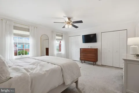 a spacious bedroom with a bed a chandelier and a dresser