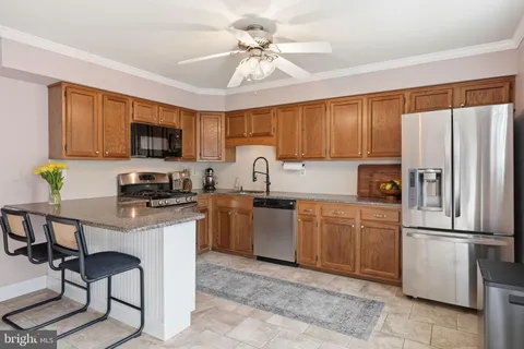 a kitchen with a refrigerator a stove a sink a washer and dishwasher with wooden floor