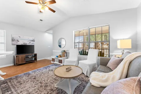 a living room with furniture a window and a flat screen tv