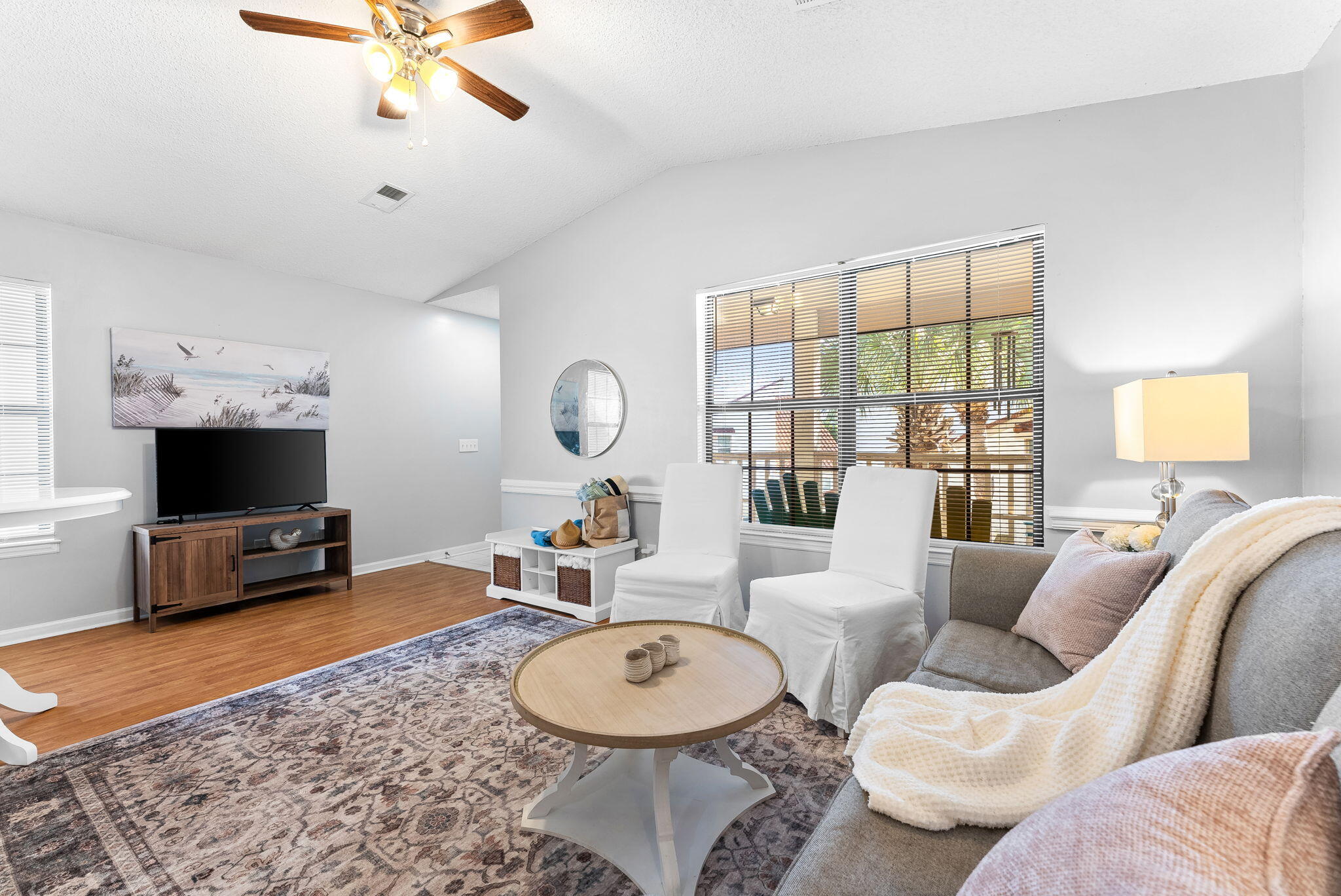 a living room with furniture a window and a flat screen tv