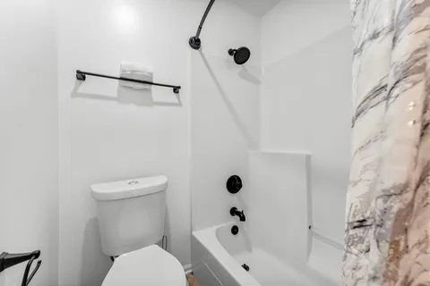 a bathroom with a toilet and a tub