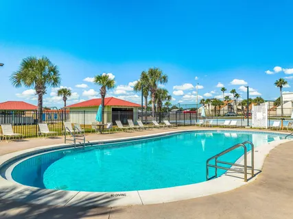 a view of a swimming pool with a lawn chairs under an umbrella
