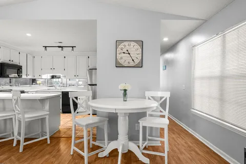 a view of kitchen with cabinets table and chairs
