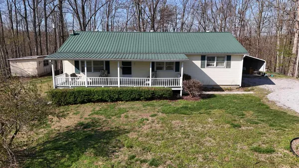 a front view of a house with a yard and trees