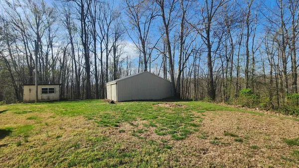 a view of a house with backyard and trees