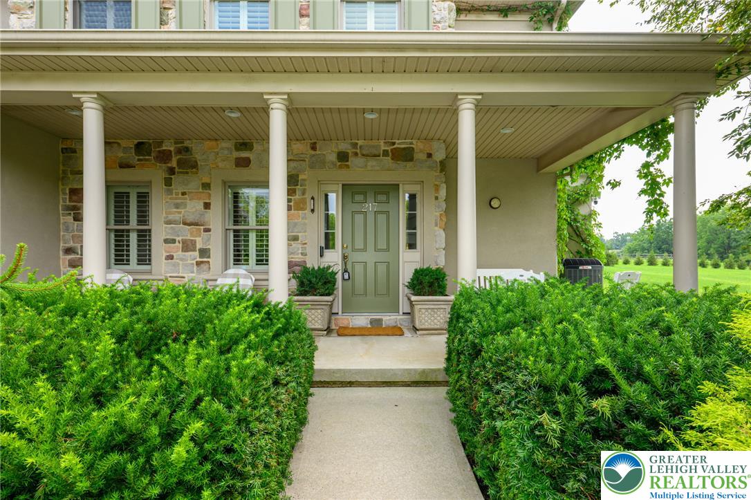 217 Gower Road Nazareth, PA 18064 - Photo 4 of 44 A welcoming front entrance, framed by lush green shrubs and classical columns, hints at stately comfort within.