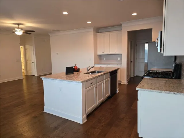 a kitchen that has a lot of cabinets in it and wooden floor