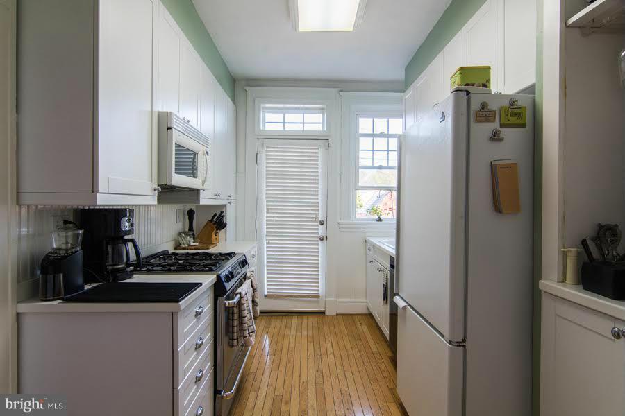 3933 Keswick Road Baltimore, MD 21211 - Photo 9 of 21 a kitchen with a refrigerator and a stove top oven