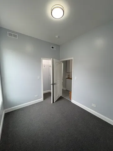 an empty room with closet and a window