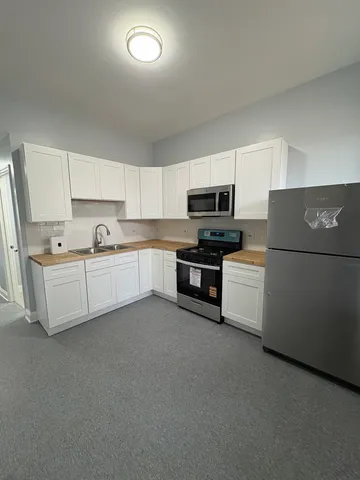 a kitchen with cabinets a sink and white appliances