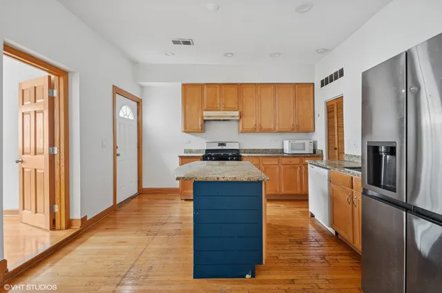a kitchen with wooden floors and stainless steel appliances