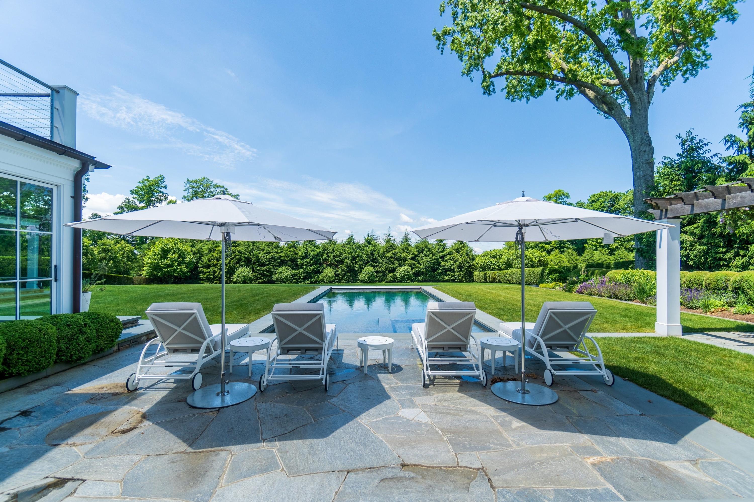 90 Long Neck Point Road Darien, CT 06820 - Photo 4 of 37 a view of a patio with chairs and table under an umbrella