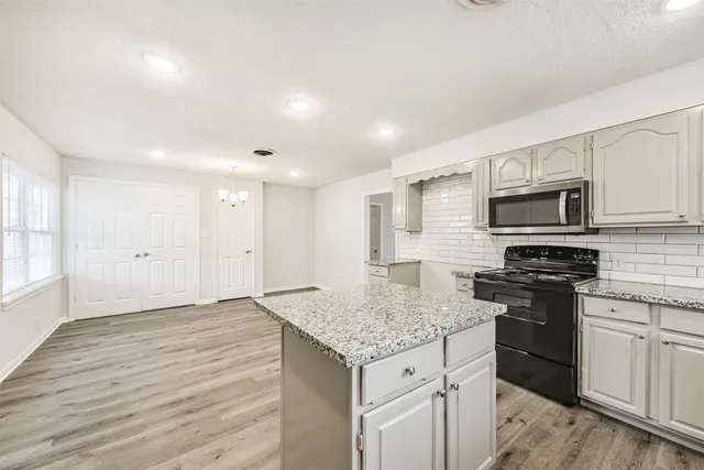 a kitchen with granite countertop kitchen island wooden cabinets granite counter tops and white appliances