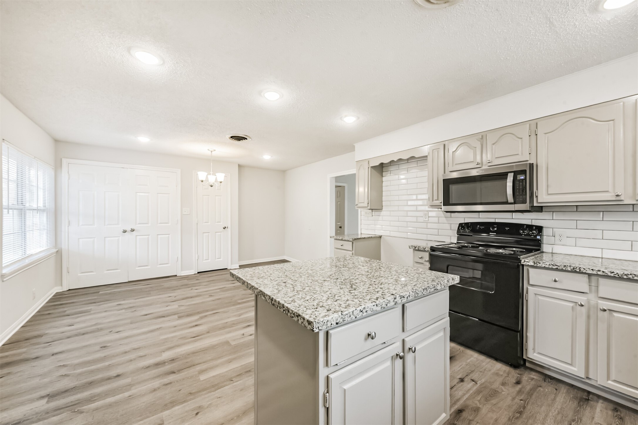 1030 Perkins Drive Bacliff, TX 77518 - Photo 11 of 30 a kitchen with granite countertop kitchen island wooden cabinets granite counter tops and white appliances