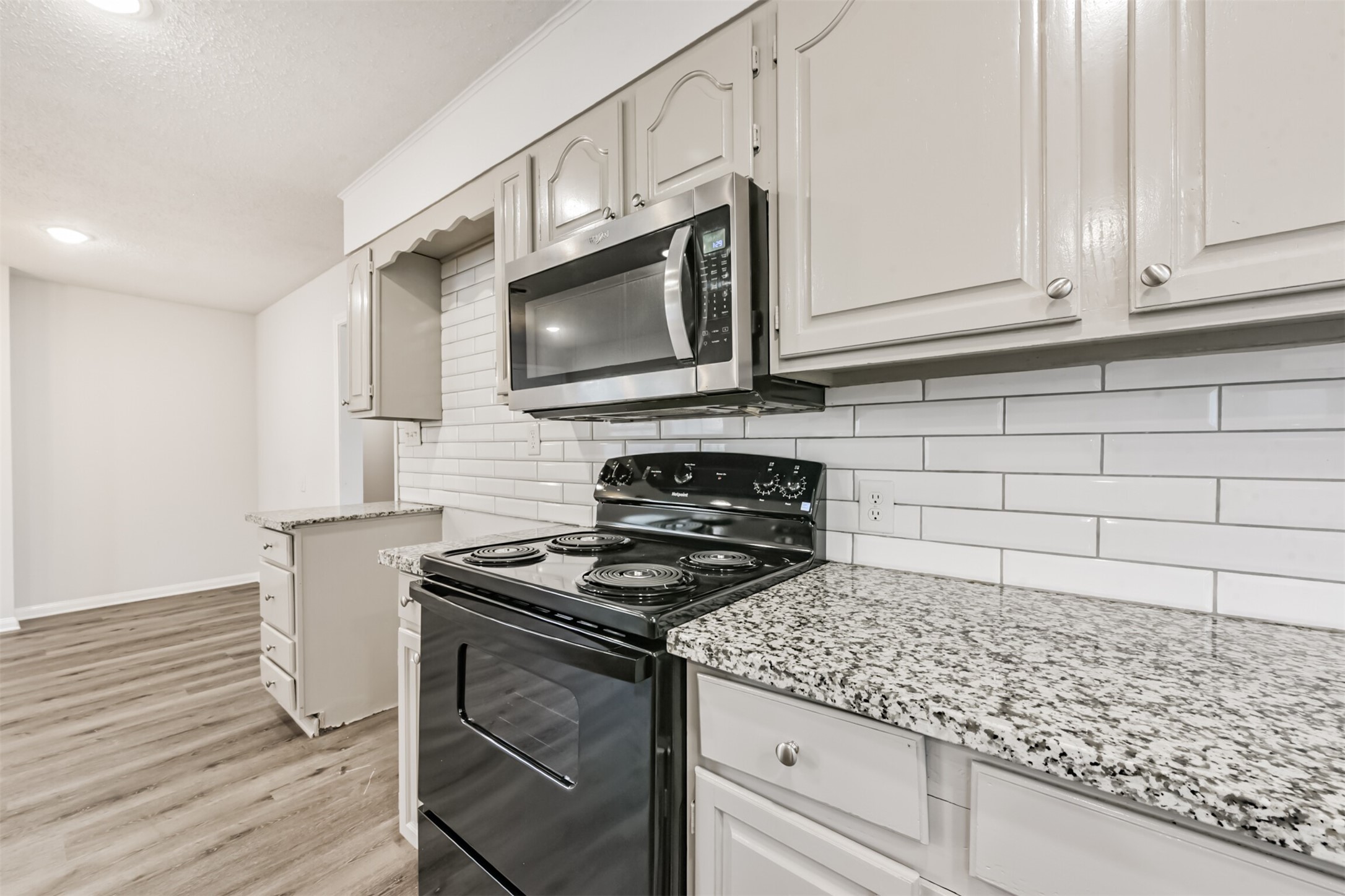 1030 Perkins Drive Bacliff, TX 77518 - Photo 14 of 30 a kitchen with granite countertop cabinets stainless steel appliances and wooden floor