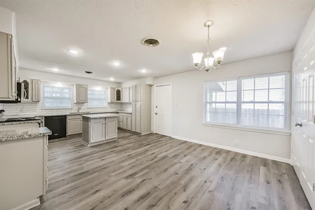 a large kitchen with kitchen island a sink stainless steel appliances and cabinets