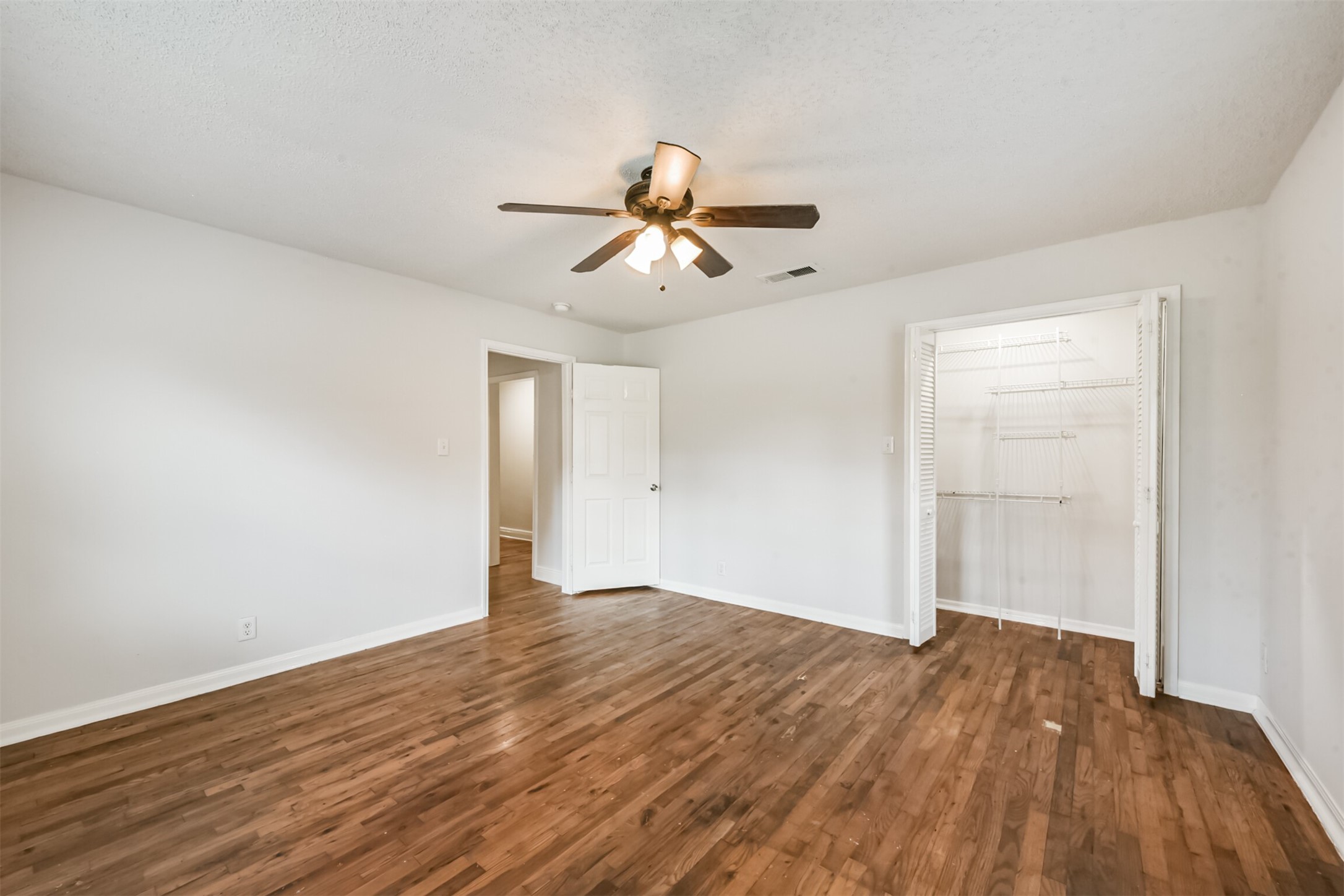 1030 Perkins Drive Bacliff, TX 77518 - Photo 21 of 30 a view of a room with wooden floor and a ceiling fan