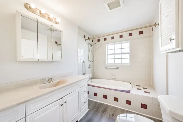 a bathroom with a double vanity sink a mirror and a bathtub