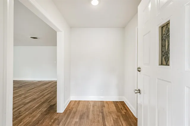 a view of a hallway with wooden floor and closet area