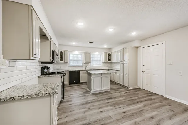 a kitchen with a sink stove top oven and cabinets