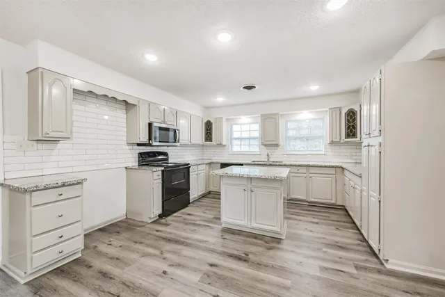 a kitchen with granite countertop white cabinets and white appliances
