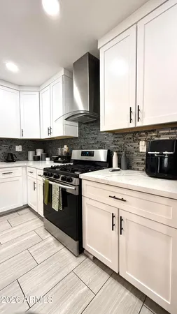 a kitchen with granite countertop white cabinets and white appliances