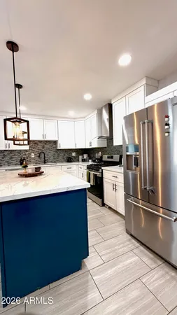 a kitchen with stainless steel appliances granite countertop a sink a stove a refrigerator and cabinets