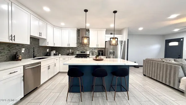 a kitchen with stainless steel appliances kitchen island granite countertop a sink and cabinets