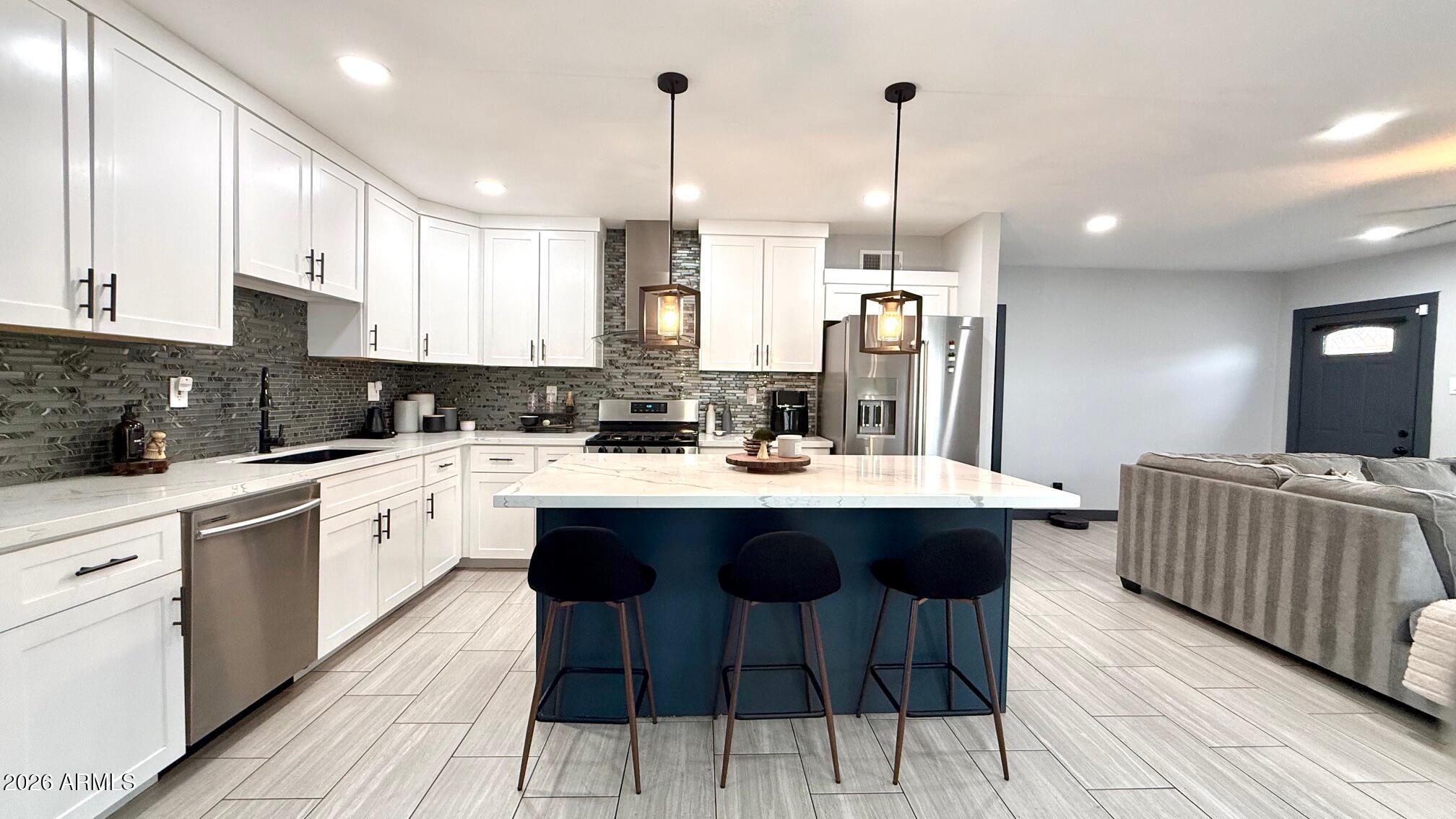 1109 West Indian School Road Phoenix, AZ 85013 - Photo 15 of 38 a kitchen with stainless steel appliances kitchen island granite countertop a sink and cabinets