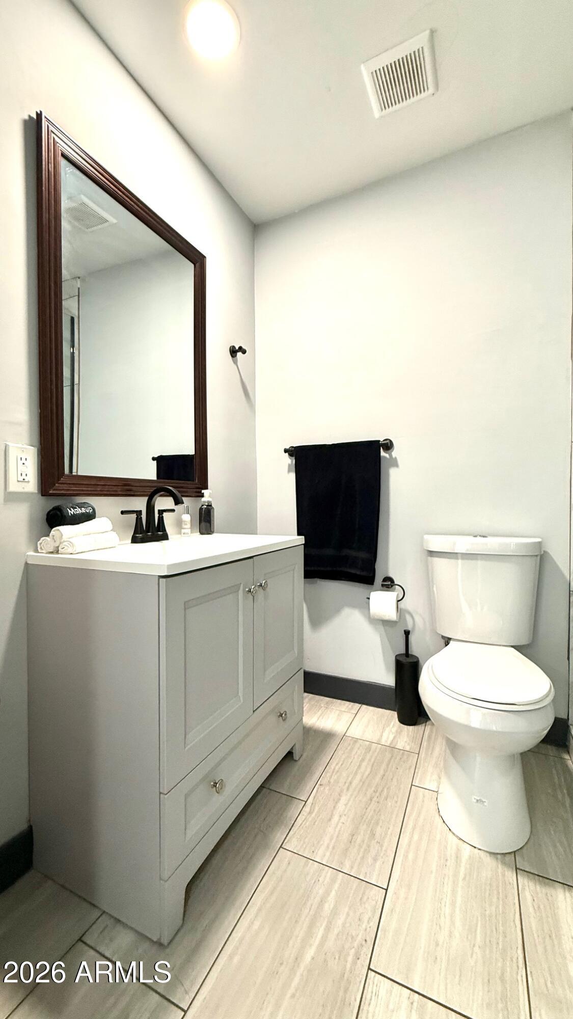 1109 West Indian School Road Phoenix, AZ 85013 - Photo 26 of 38 a bathroom with a toilet a sink and mirror