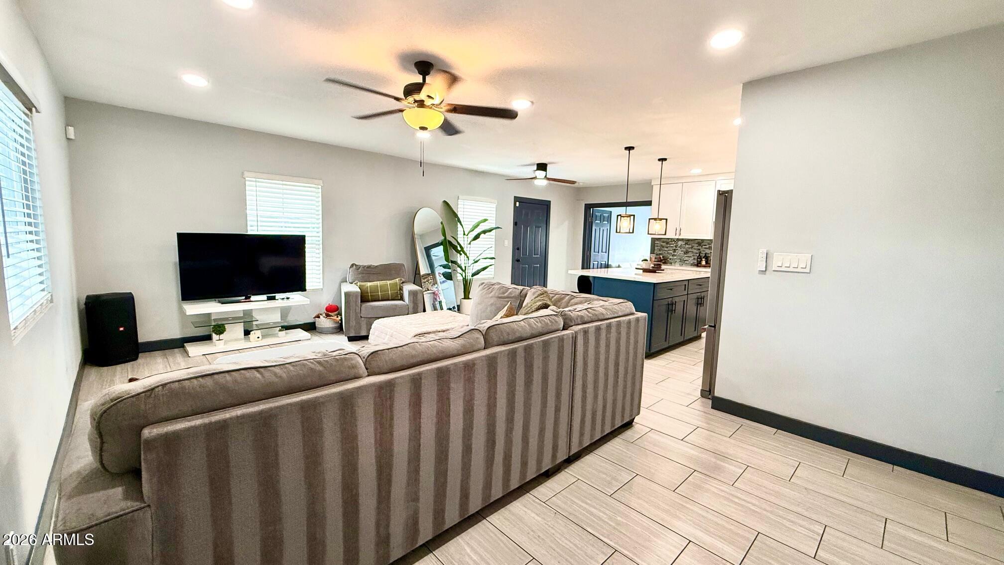 1109 West Indian School Road Phoenix, AZ 85013 - Photo 6 of 38 a room with a bed a flat screen tv and a couch