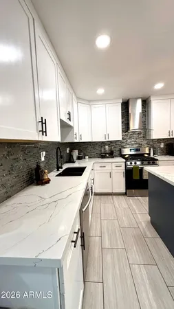 a kitchen with stainless steel appliances granite countertop a stove a sink and a microwave