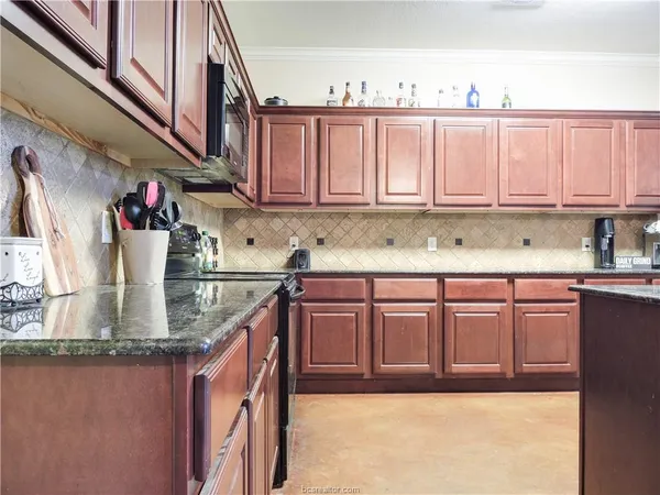 a kitchen with stainless steel appliances granite countertop a sink a stove and dishwasher