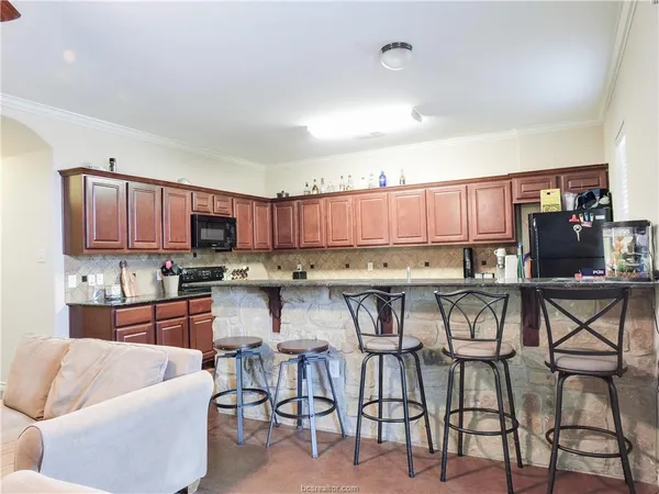 a kitchen with stainless steel appliances lots of white cabinets and furniture