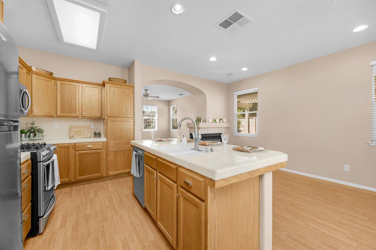 785 West Riviera Lane Clovis, CA 93619 - Photo 15 of 35 a kitchen with a sink stove and wooden cabinets