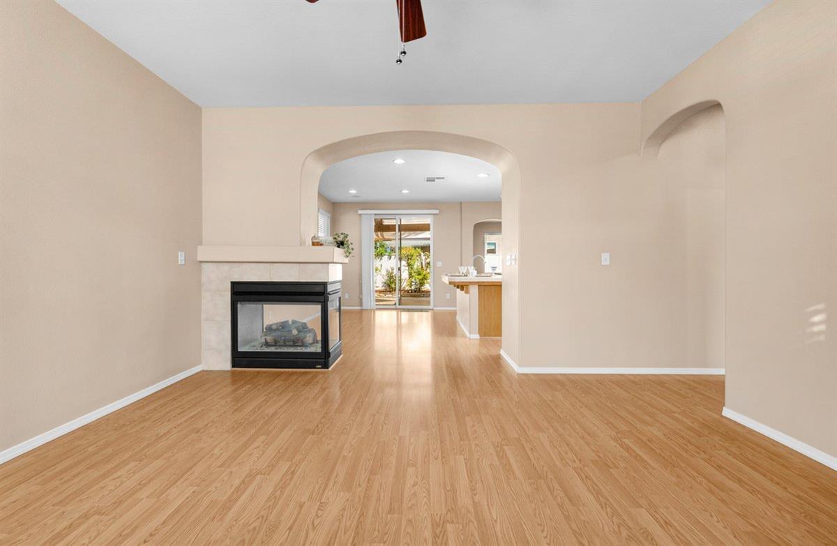785 West Riviera Lane Clovis, CA 93619 - Photo 7 of 35 an empty room with wooden floor fireplace and windows