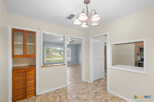 a view of an empty room with a fireplace and a window