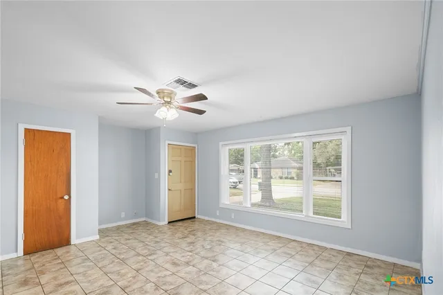 a view of an empty room with window and cabinet