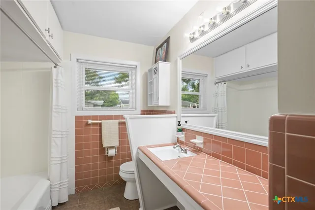 a front view of a house with a garden and trees