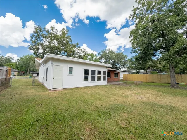 a front view of house with yard and trees